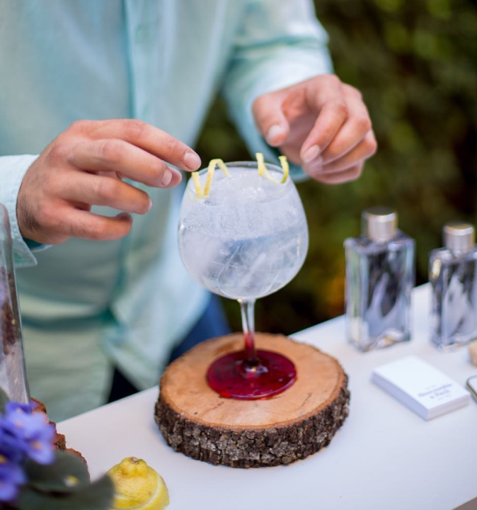 Gin tonic servido en copa de balón con guarnición cítrica.