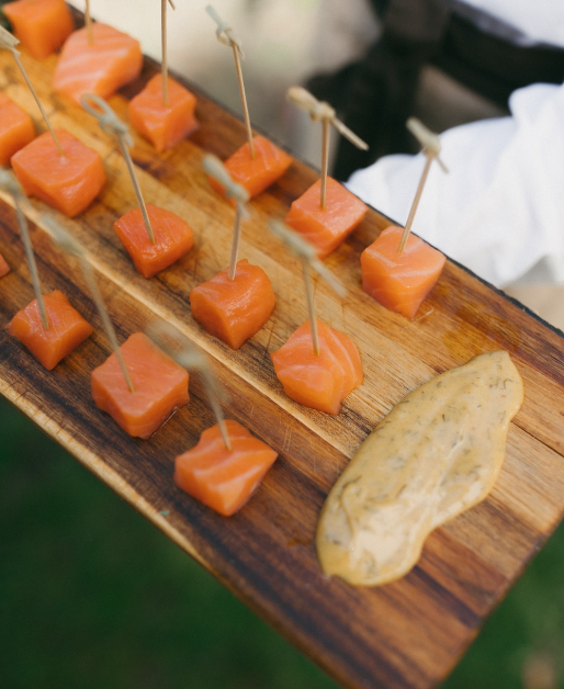 Dados de salmón marinado sobre tabla de madera.